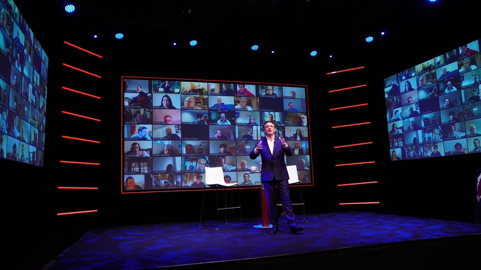 Presenter on the Studio A stage with the remote audience on three video walls