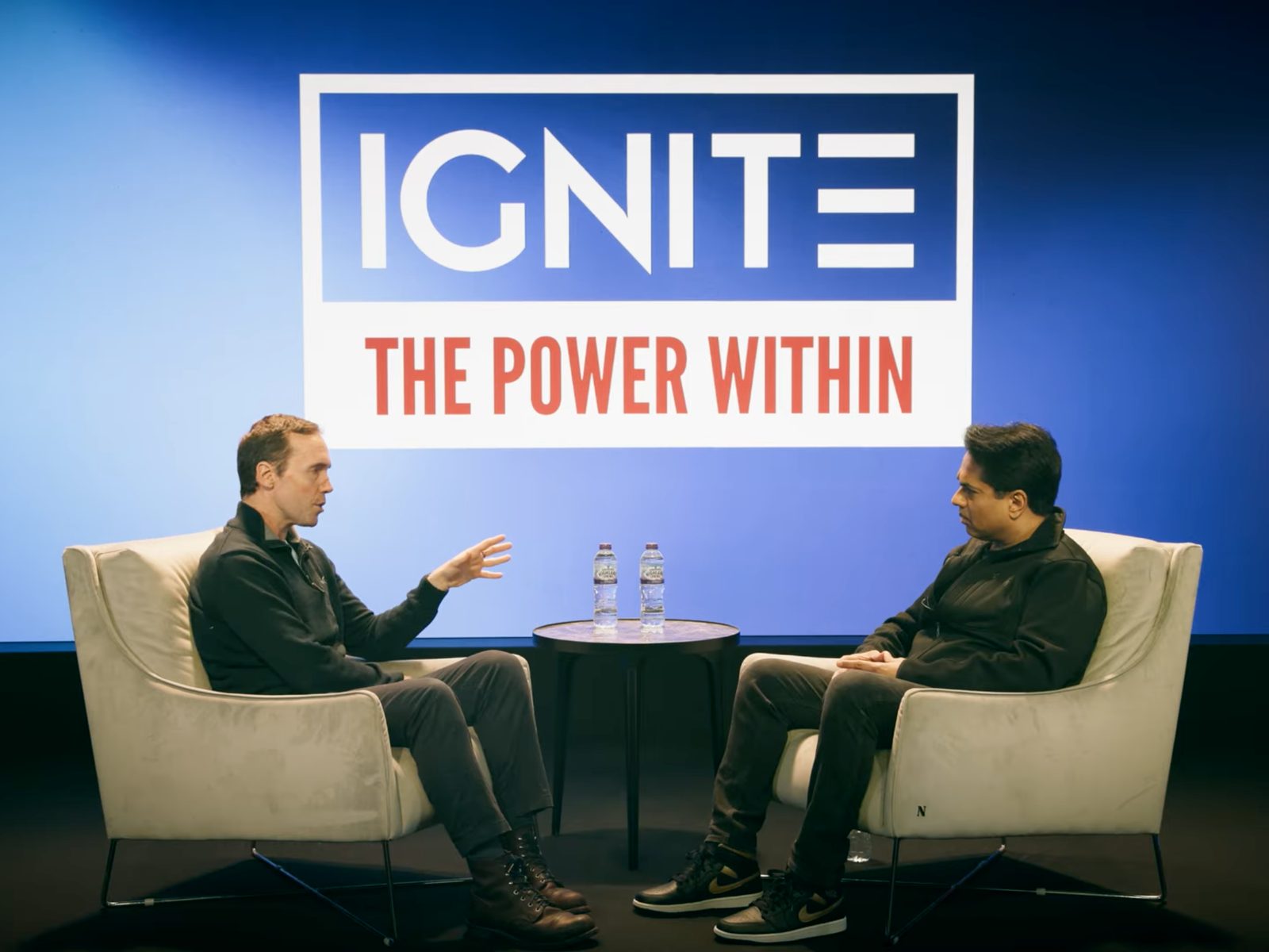 Host and guest in armchairs recording an episode of IGNITE: The Power Within